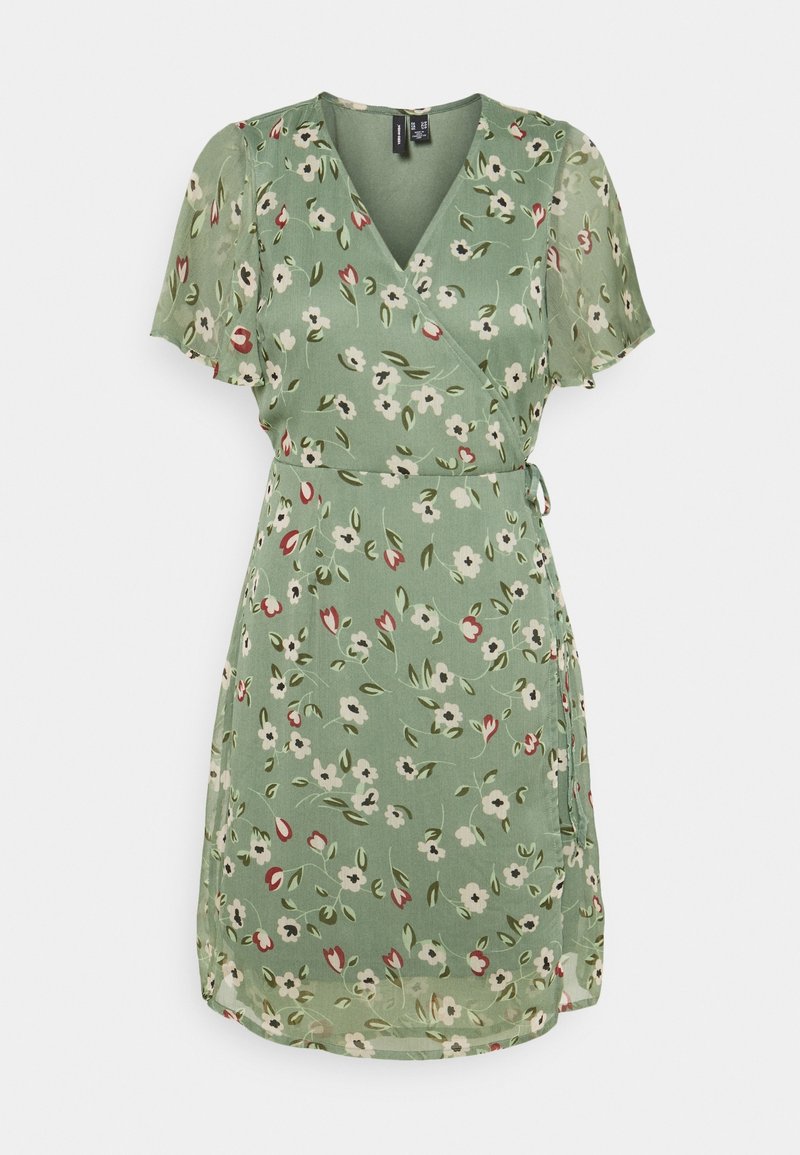 Robe portefeuille verte à motif floral avec manches courtes volantes et ceinture à nouer sur le côté sur fond blanc uni.