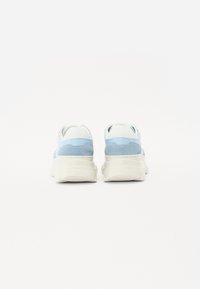 Lys blå og hvite sneakers med en klumpete såle, laget av semsket og glatt skinn, med kontrasterende paneler og sømdetaljer.
