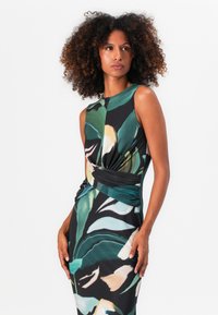 Ärmelloses Kleid mit dunklem Hintergrund und großen grünen und cremefarbenen Blättermustern, drapiertem Taillendetail und glatter Stofftextur.