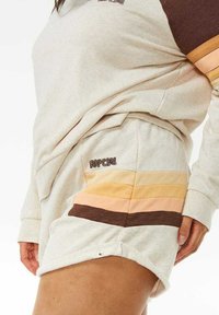 Conjunto de sudadera y pantalones cortos en gris claro con rayas horizontales marrones y en tonos pasteles; presenta una tela suave y detalle de logo en los pantalones cortos.
