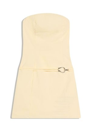 Mini abito giallo chiaro senza spalline con corpetto aderente e sottile cintura con fibbia a forma di goccia d'argento in vita.