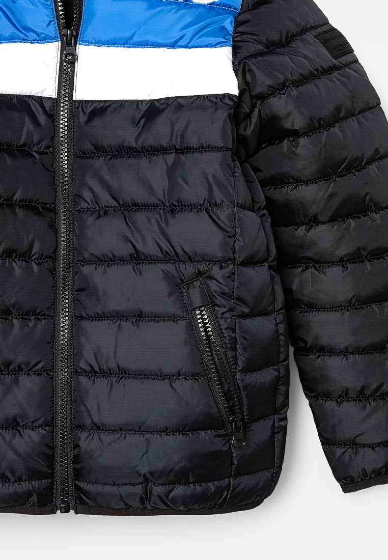 Zwarte pufferjack met blauwe en witte horizontale strepen op de borst, voorzien van een rits aan de voorkant en een zijzak van textuurstof.