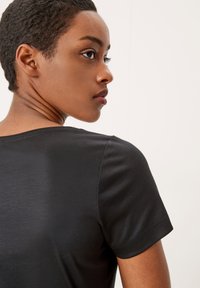 Zwarte T-shirt met korte mouwen van gladde stof, met een ronde hals en een klassieke pasvorm, van achteren bekeken met zichtbare naden.