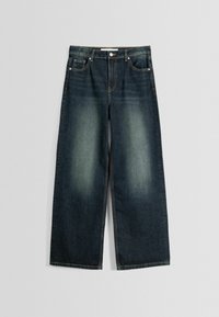 Mörkblå vida jeans i denim med urtvättade framtill på låren, framfickor, bältesöglor och knappstängning på en ljusgrå bakgrund.