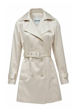 Abrigo trench beige de doble botonadura hecho de tela suave, con cintura ceñida, grandes solapas y dos bolsillos delanteros con detalles de botones.