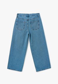 Jeans de mezclilla de tiro alto, de pernera amplia y color azul claro, con dos bolsillos traseros y un dobladillo sin rematar. La tela tiene un aspecto texturizado clásico.