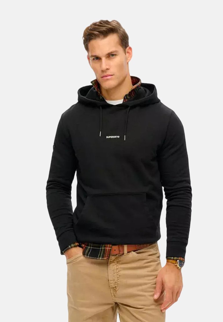 Zwarte hoodie met een voorzak, een capuchon met koordjes en geborduurd "SUPERDRY" logo. Gecombineerd met een geruit flanellen shirt eronder.