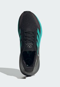 Scarpa sportiva nera con accenti turchesi, tomaia texturizzata e chiusura con lacci. Presenta una suola ammortizzata e dettagli di marca sul lato.