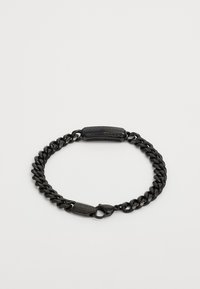 Bracelet en chaîne noire avec maillons, doté d'un fermoir texturé et de quincaillerie. Le matériau semble métallique avec une finition lisse.