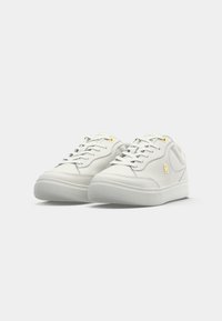 Hvite lær sneakers med glatt overflate, med gullhull og logodetalj, rund tå, og en strukturert gummisåle.
