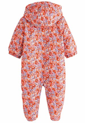 Combinaison à motifs floraux avec un fond rose, présentant des fleurs rouges et violettes vives, une capuche, des poignets élastiques et des ouvertures pour les jambes.