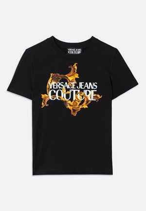 T-shirt de algodão preta com texto branco "VERSACE JEANS COUTURE" e um design dourado ornamental em volta do texto, mangas curtas e gola redonda.