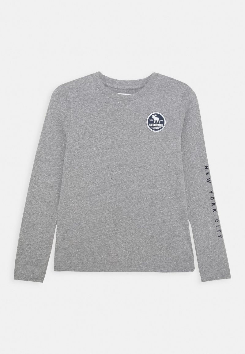 Camiseta de manga larga gris claro con cuello redondo y texto "New York City" en la manga derecha, y un logotipo redondo de Abercrombie en el pecho izquierdo.