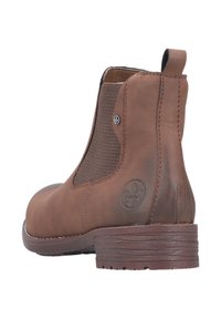 Brązowy skórzany botek sięgający kostki z elastycznymi panelami bocznymi i fakturowanym wzorem. Zawiera detal z logo oraz niski, zbity obcas.