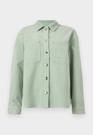Chemise en velours côtelé vert clair à boutons, avec deux poches poitrine et manches longues, dotée d'un col classique.