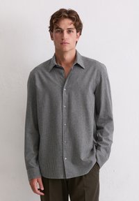 Langärmliges Button-Up-Hemd in einem schwarz-weißen Karomuster, mit klassischem Kragen, weichem Stoff und glatten Knöpfen.
