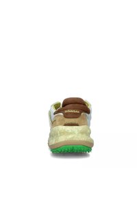 Sneaker con tomaia in tessuto bianco, dettagli in suede marrone e una suola intermedia spessa e strutturata. Suola verde con punti di trazione rialzati.