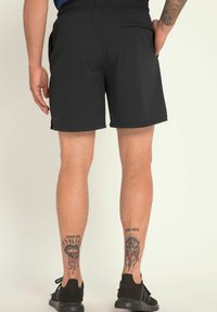 Sorte atletiske shorts lavet af let, glat stof. Har en elastisk talje og en lynlåslomme bagpå.