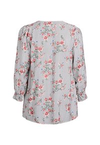 Blouse florale avec un motif à rayures blanches et noires, ornée de roses roses et de petits accents bleus. Manches smockées avec une coupe décontractée.
