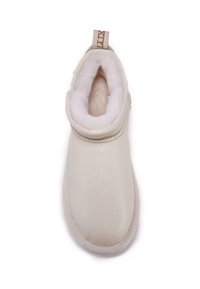 Botín de cuero beige hasta el tobillo con un suave forro de cal fleece de color claro, punta redondeada, detalles cosidos y una lengüeta de tela.