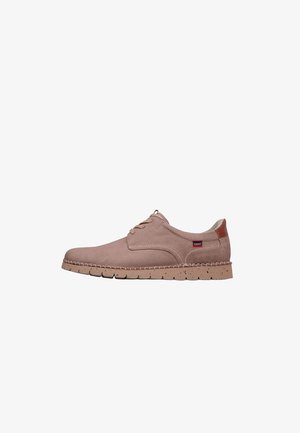 Zapato casual de ante marrón claro con cordones, suela cosida, suela exterior de goma moteada y pequeña etiqueta de tela de la marca cerca del talón.