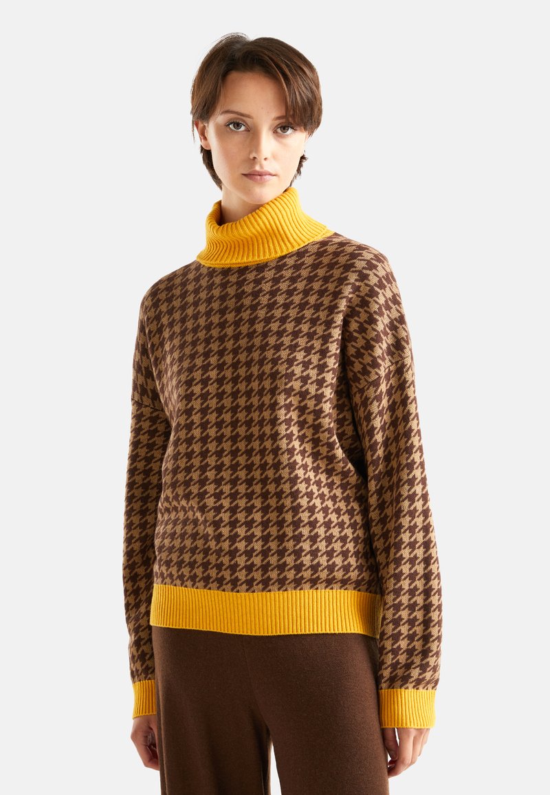 Brązowy i żółty sweter z golfem w wzór houndstooth, z prążkowanym kołnierzem i mankietami, o luźnym kroju i miękkiej teksturze.