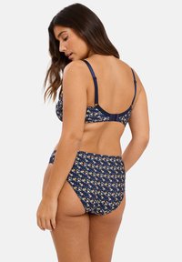 Conjunto de lencería floral en azul marino con tirantes ajustables, que incluye un sujetador con estampado y una braga de cintura alta, fabricado en una suave y elástica tela.