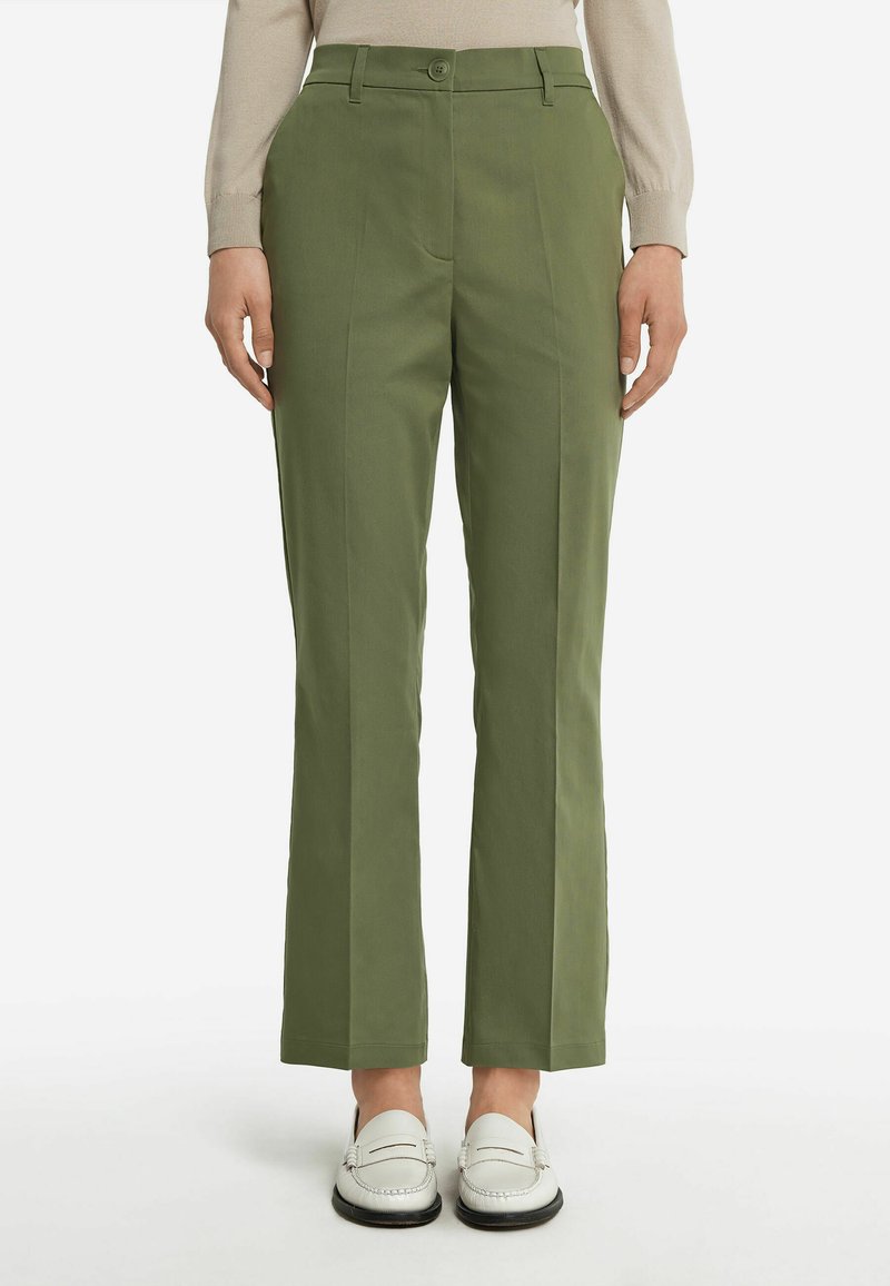 Gröna skräddarsydda byxor med rak skärning, med fåror framtill, sidofickor och knäppning med knapp. Matchas med vita loafers.