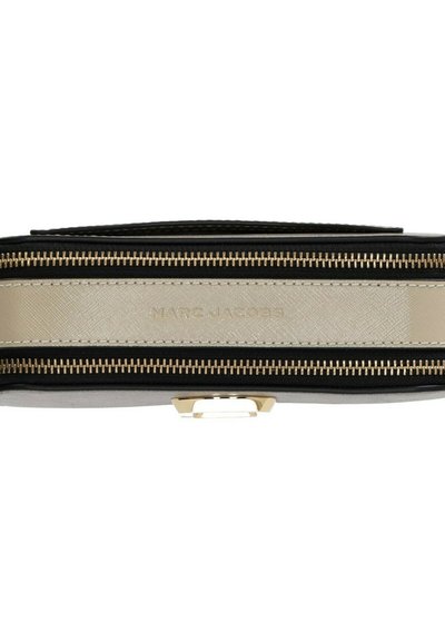 Vista dall'alto di una borsa Marc Jacobs beige e nera con due cerniere dorate e un manico nero.