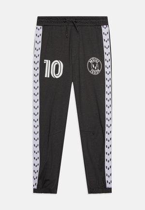 Graue Sporthose mit schwarzen Seitenelementen und geometrischem Muster, weißen Grafiken einschließlich der Zahl "10" und dem "MESSI"-Logo.