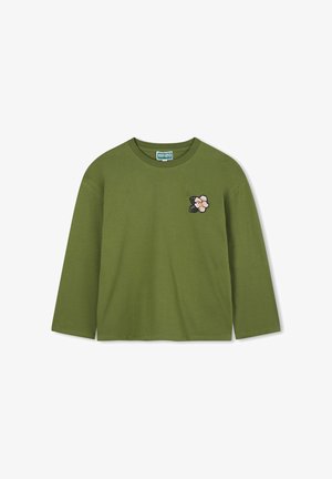 Olijfgroen langemouwen shirt van zachte katoen, met een roze en zwarte geborduurde bloemenpatch op de linkerkant van de borst. Ronde halslijn.