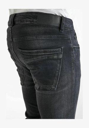 Donker gewassen denim jeans met een slim fit. Voorzien van een zwart leren taillebandlabel en klassieke achterzakken met subtiele stikseldetails.