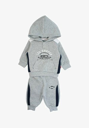 Ensemble sweatshirt gris et pantalon assorti en tissu doux. Comprend une capuche, une poche avant et des rayures latérales bleu marine avec des détails de marque.