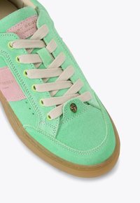 Sneaker verde in camoscio con dettagli rosa, lacci e suola in gomma. Presenta un logo sul lato e dettagli di cucitura attorno alla punta.