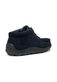 Botas de ante azul marino hasta el tobillo con punta redondeada, diseño de cordones y suela de goma negra con texturas antideslizantes. La vista trasera resalta la silueta.