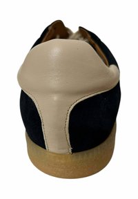 Zapato de ante negro y cuero beige con tacón redondeado, que presenta un diseño trasero en contraste y una suela translúcida.