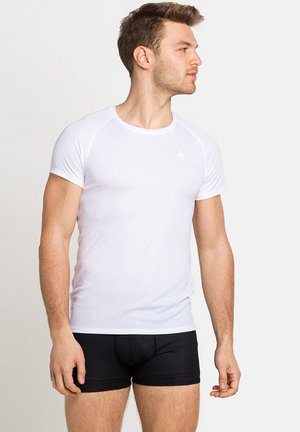 T-shirt blanc à manches courtes avec un col rond et une coupe légèrement ajustée, associé à un boxer noir. Texture de tissu lisse.