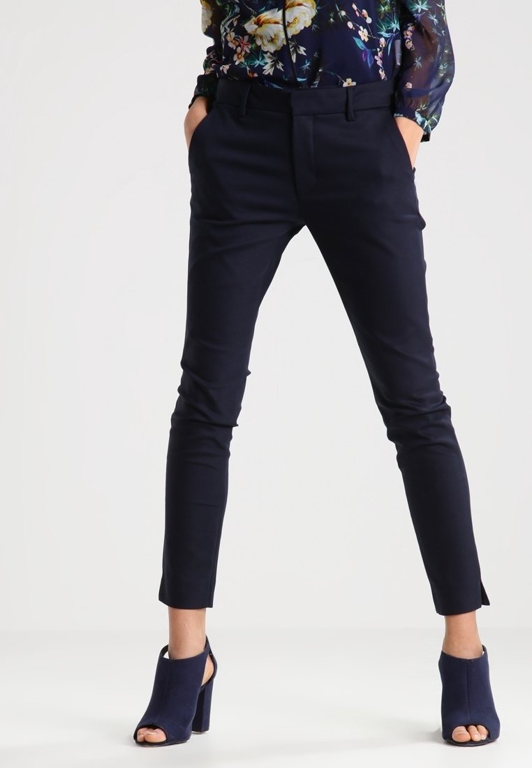 Marina skräddarsydda byxor med slim fit, med en mjuk textur, snedställda fickor och kort längd, i kombination med marina klackade ankelstövlar.