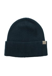 Knitted beanie in dark teal with a ribbed cuff and a tan logo patch. Made from a soft fabric with a textured finish.