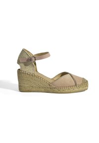 Espadrille à talon compensé avec une tige en suède marron, un talon en paille tressée et une lanière à la cheville. Caractérisée par un design à bout ouvert et des accents cousus.