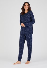 Navyblauwe pyjama-set van zacht katoen, bestaande uit een langemouwen top en slim-fit broek, beide versierd met witte maanpatronen.