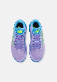 Lila sportcipők kék kiegészítőkkel, légáteresztő hálós felsőrész, fűzővel záródó dizájn és élénk sárga New Balance logó. Texturált talp.