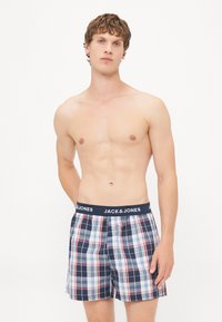 Sjekkede boksershorts med navyrand som har "JACK & JONES"-logo. Fargene inkluderer navy, rød og hvit i et rutemønster.