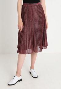 Plisserad midiklänning i metallisk bourgogne-tyg med en texturerad yta, som har en åtsittande midja och en flödande design. Framträdande med genomskinliga lager.