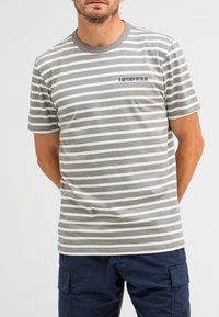 Grau-weiß gestreiftes T-Shirt mit rundem Halsauschnitt, kurzen Ärmeln und einem blauen Textlogo auf der Brust. Das Material wirkt weich und lässig.