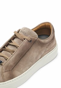 Sneakers in camoscio color beige chiaro con lacci abbinati, suola in gomma bianca e logo impresso sulla linguetta. Fodera interna liscia.