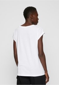 Weißes, kurzärmliges T-Shirt aus Baumwolle mit rundem Ausschnitt und umgeschlagenen Ärmelenden, entspannter Schnitt und ohne sichtbare Muster.