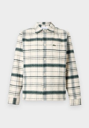 Camicia a maniche lunghe con bottoni, base crema, motivo scozzese verde e nero, tasca frontale e piccolo logo coccodrillo verde ricamato sul petto.