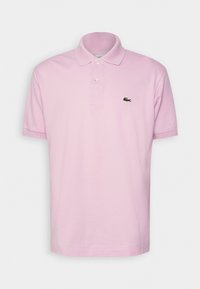 Polo shirt rose clair en coton doux, doté d'un col classique, d'une patte de boutonnage à trois boutons et d'un logo crocodile vert sur la poitrine gauche.