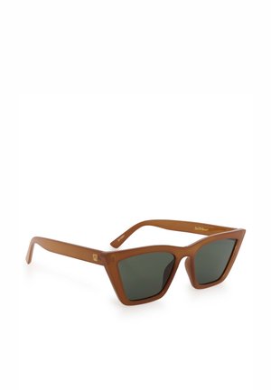 Lunettes de soleil cat-eye marron avec des verres foncés et un petit logo doré sur les branches, présentées sur fond blanc.